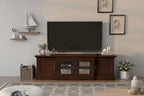 Wooden TV stand with a television in a living room setting.